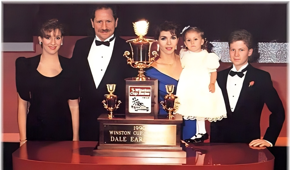 The Earnhardt family clinking a picture with Dale's 1990 Winston Cup.